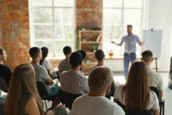 People sitting in a training, with a male speaker up front