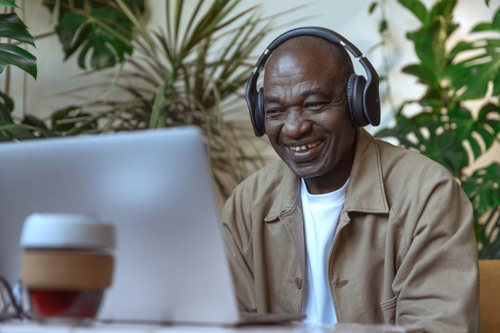 Man with headphones smiling at computer